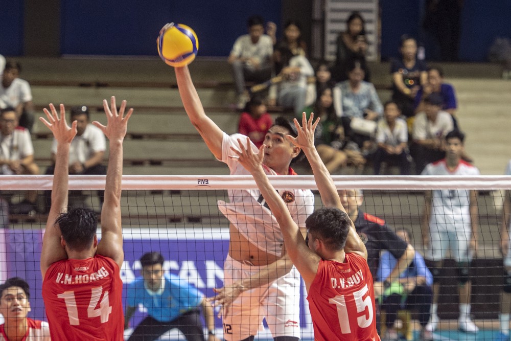 Pevoli putra Indonesia Nurmulki Rivan (tengah) melakukan smes ke arah Timnas Voli putra Vietnam. ANTARA FOTO/Muhammad Adimaja